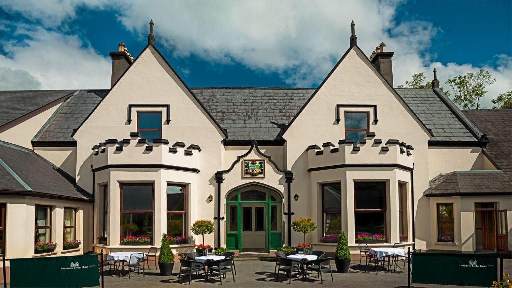 a house with tables and chairs in front of it at Oranmore Lodge Hotel Conference And Leisure Centre Galway in Oranmore