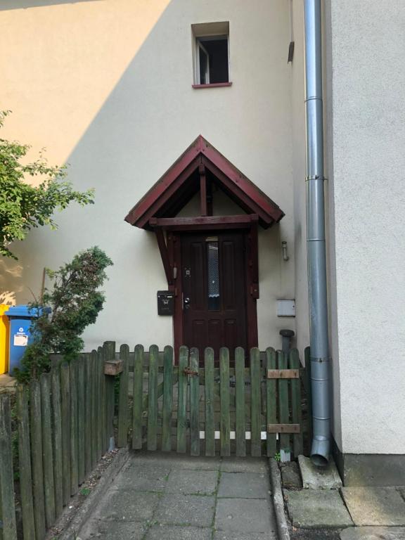 een houten deur op een huis met een hek bij Urban CITY in Olecko