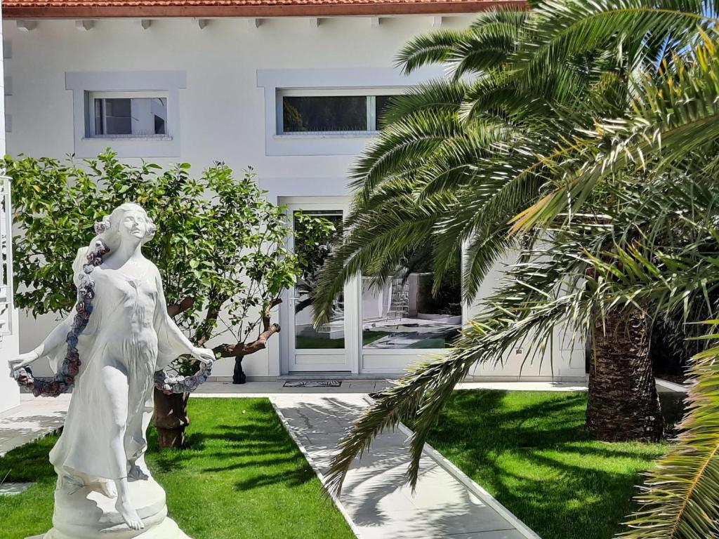 Palms Luxury Suites Sanremo في سانريمو: تمثال لامرأة امام المنزل