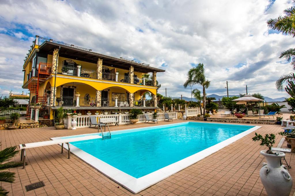 un resort con piscina di fronte a un edificio di Villa Aurelia Pompei a Pompei