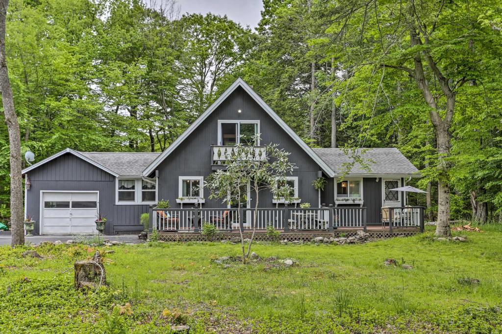 a gray house with a porch and a yard at Deck and Pool Access Welcoming Poconos Retreat in Tobyhanna