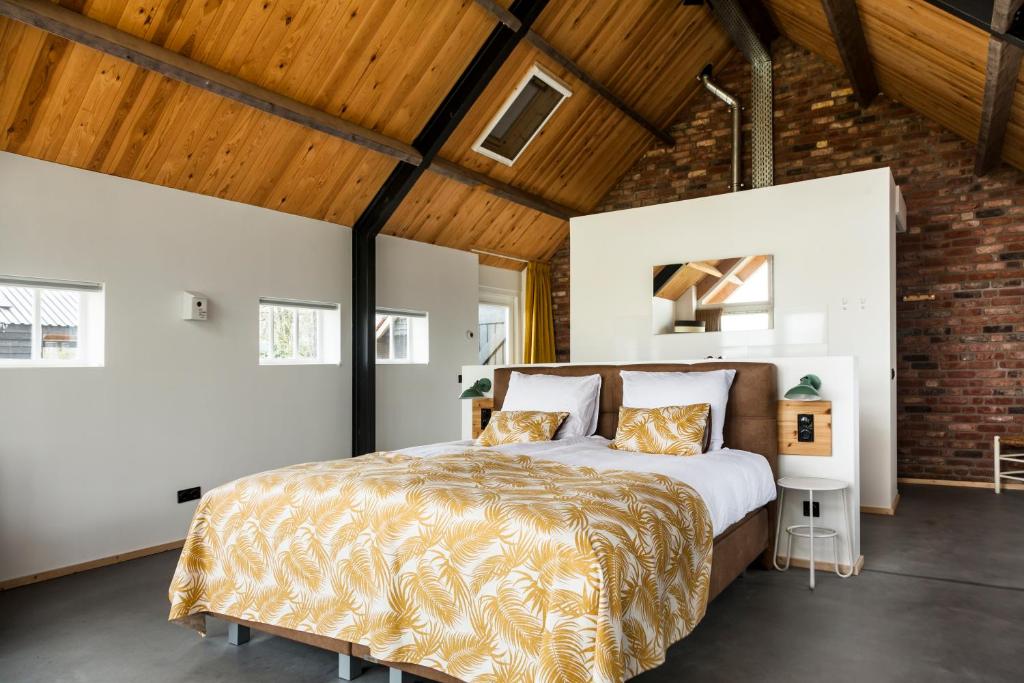 ein Schlafzimmer mit einem Bett und einer Ziegelwand in der Unterkunft B&B Grevenberg in Oosterhesselen