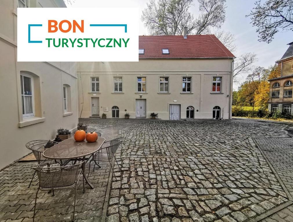 a house with oranges on a table in front of it at Pałac i Folwark Brzeźnica in Brzeźnica