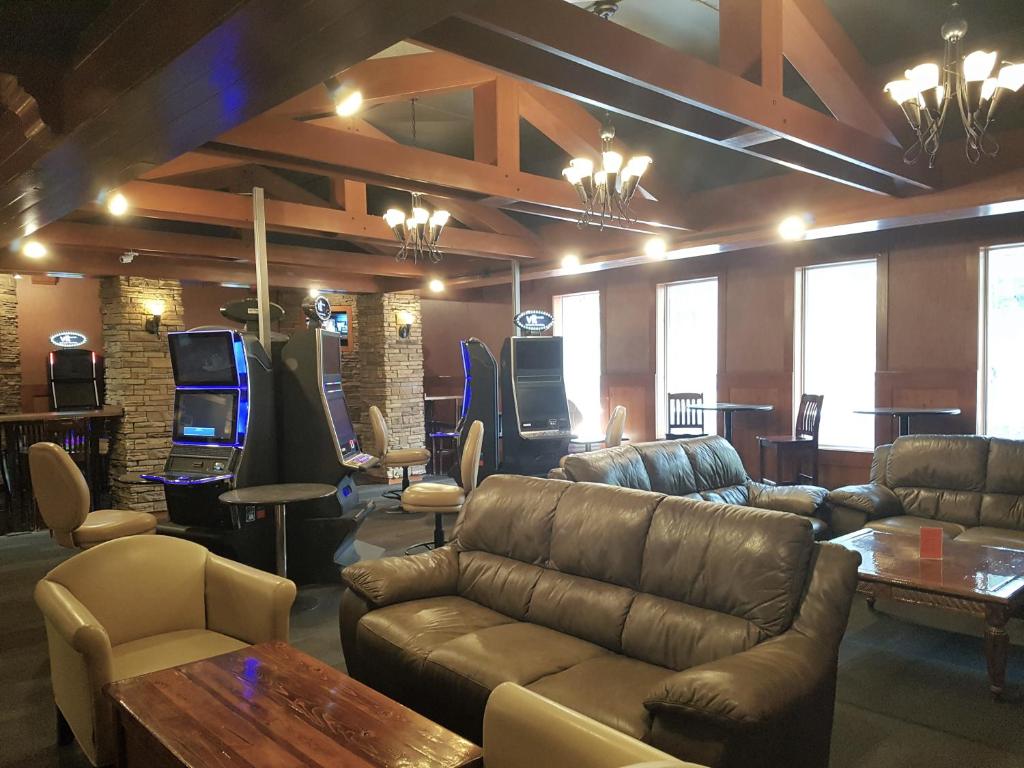 a large living room with couches and a table and chairs at Twin Pine Inn & Suites in Hinton