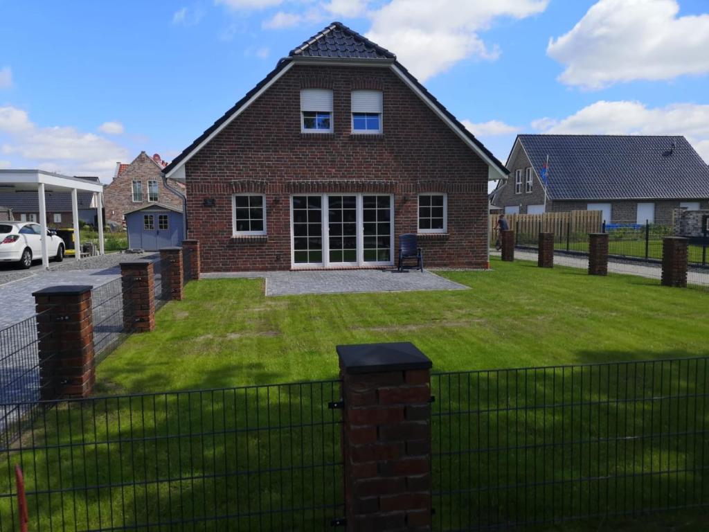 a brick house with a lawn in front of it at Dat Ankerhuus Timmel in Großefehn 