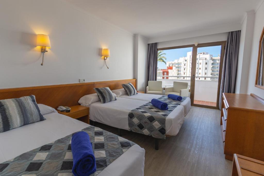 a hotel room with two beds and a balcony at R2 Veronica in Cala Millor
