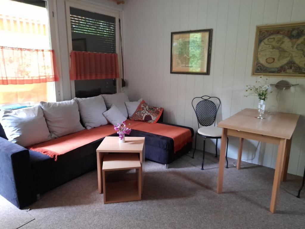 een woonkamer met een bank en een tafel bij Bungalow am Waldbad in Schmannewitz