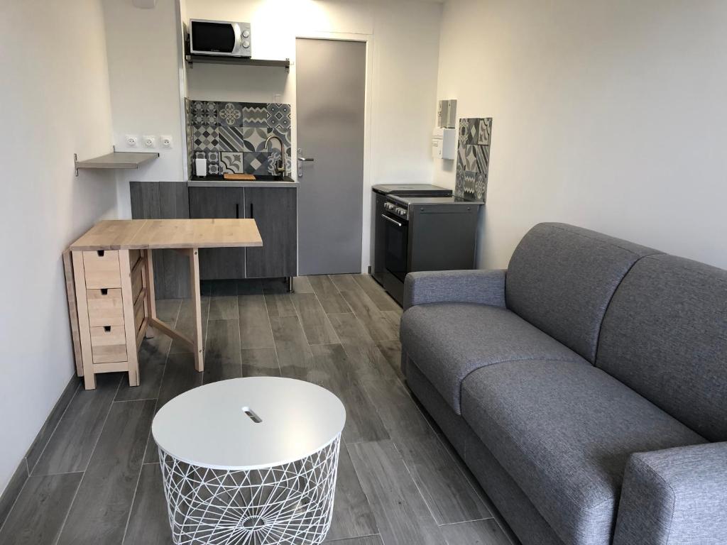 un salon avec un canapé et une table dans l'établissement Studio à 50 m de la mer avec parking privatif, à Saint-Hilaire-de-Riez