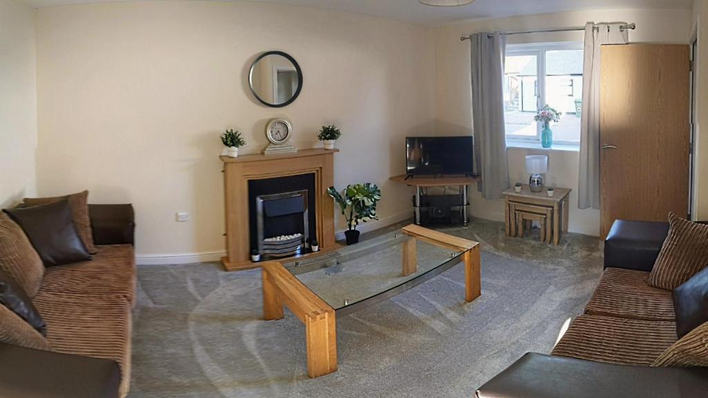 a living room with a couch and a coffee table at No2 Glan Nodwydd in Pentraeth