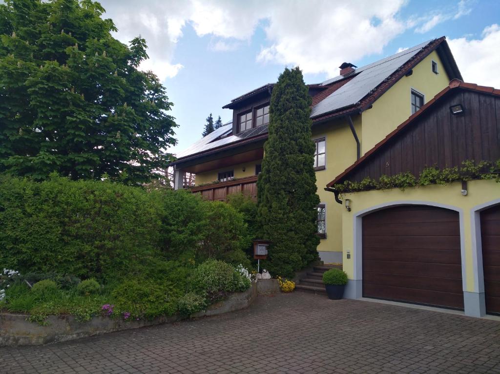 uma casa com garagem e uma entrada em Ferienwohnung Adelhardt em Eckersdorf