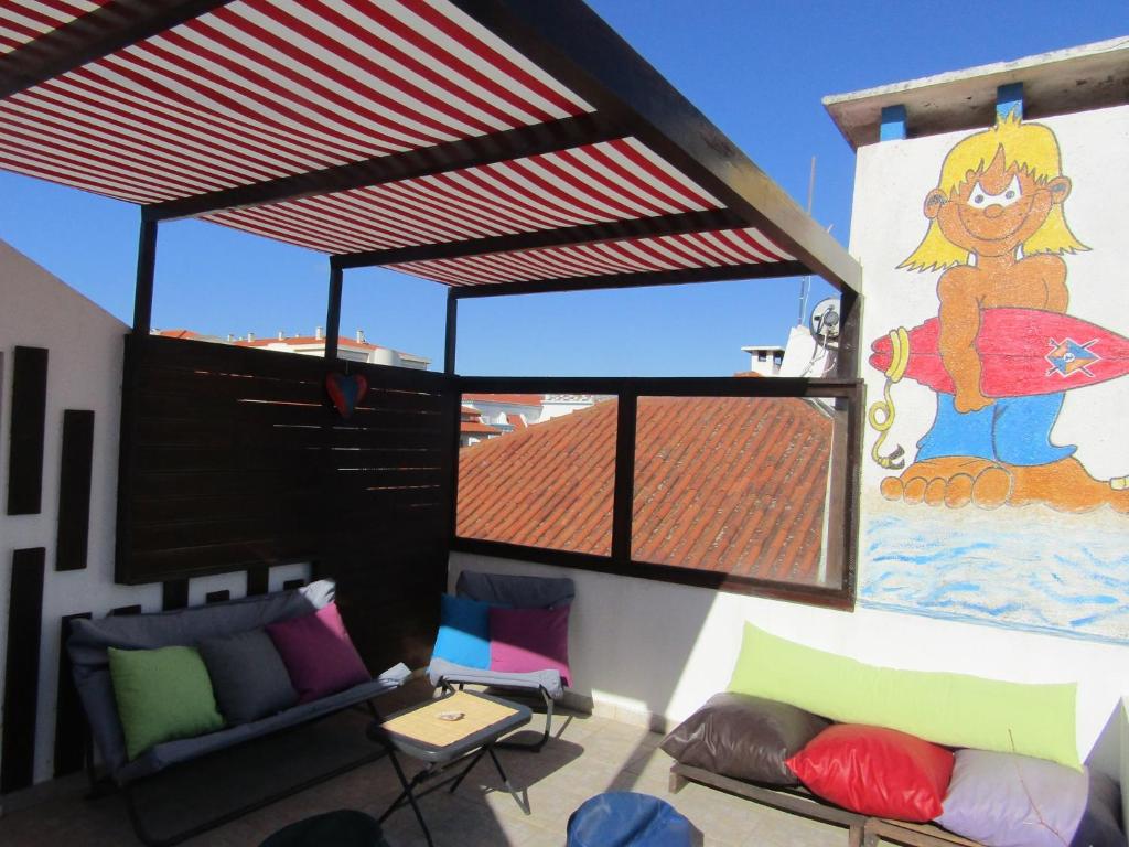 a living room with a large window with a painting on the wall at West Coast Surf Hostel in Areia Branca