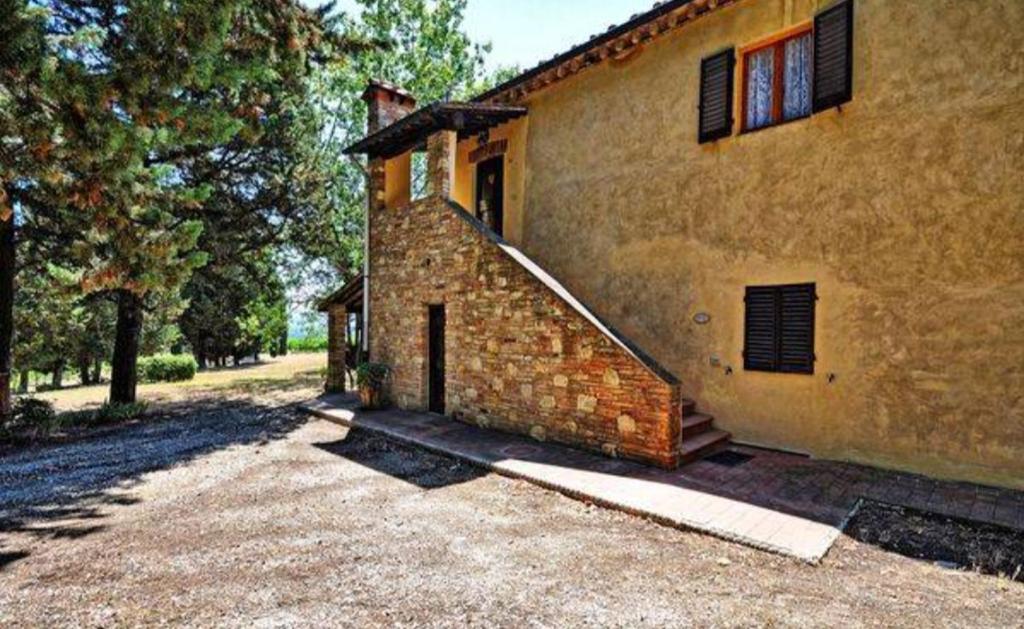 una casa de ladrillo con una escalera en el lateral de ella en Agriturismo Fattoria Il Piano - Casa Tosca - San Gimignano, en San Gimignano