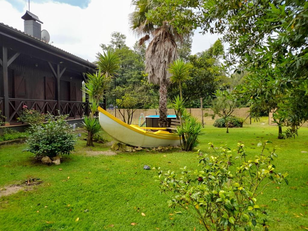 un bateau jaune assis dans une cour à côté d'une maison dans l'établissement Quinta do Bosque, à Vagos