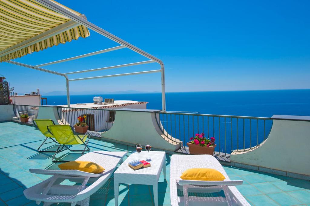 d'un balcon avec une table et des chaises donnant sur l'océan. dans l'établissement Moressas in Praiano, à Praiano