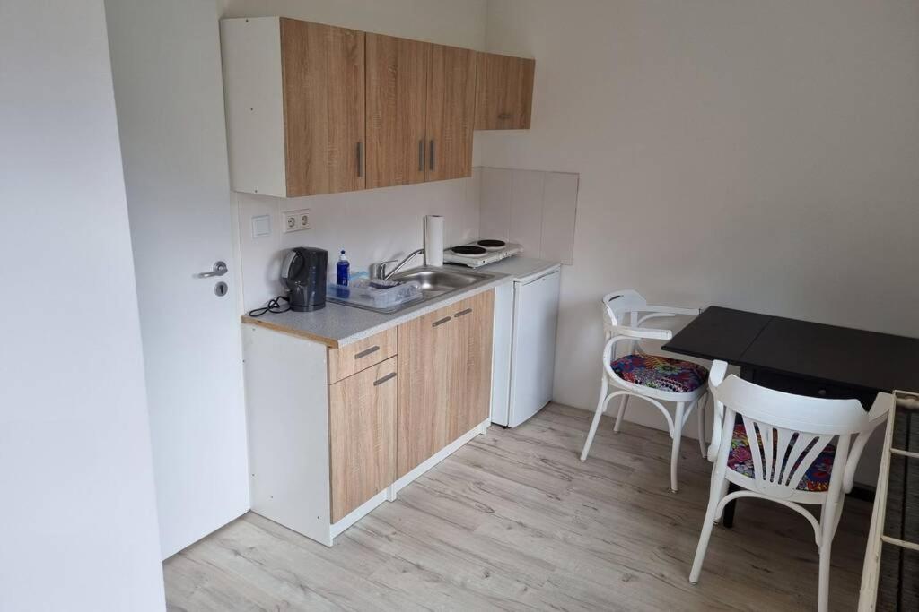 a small kitchen with a sink and a table and chairs at Ferienwohnung/Monteurwohnung Alte Garage in Weimar