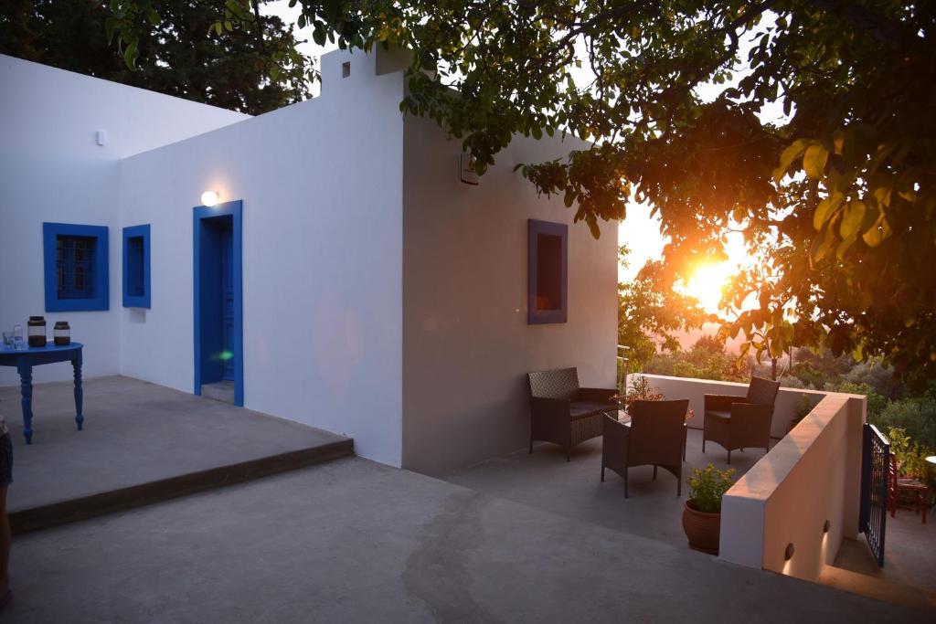 a patio with a table and chairs and a building at The Water Mill Cottage in Lagoúdi Zía