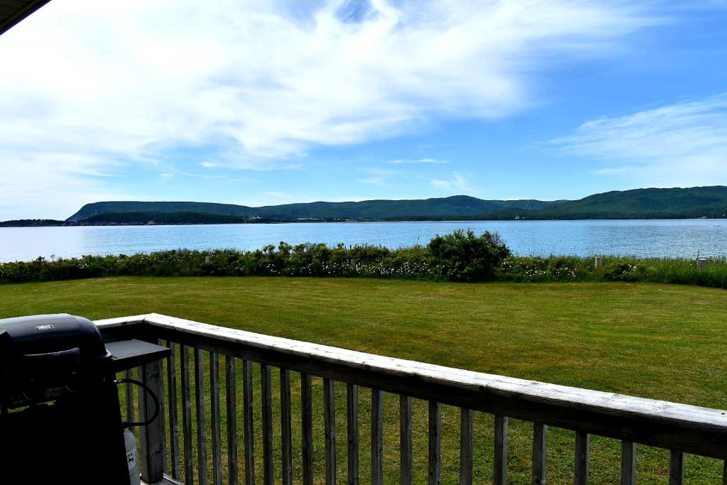 a balcony with a view of a lake at Seascape Coastal Retreat - ADULTS ONLY - HOT TUBS in Ingonish