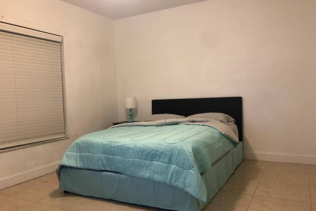 1 dormitorio con 1 cama con manta azul en Miami guest suite by airport, en Miami