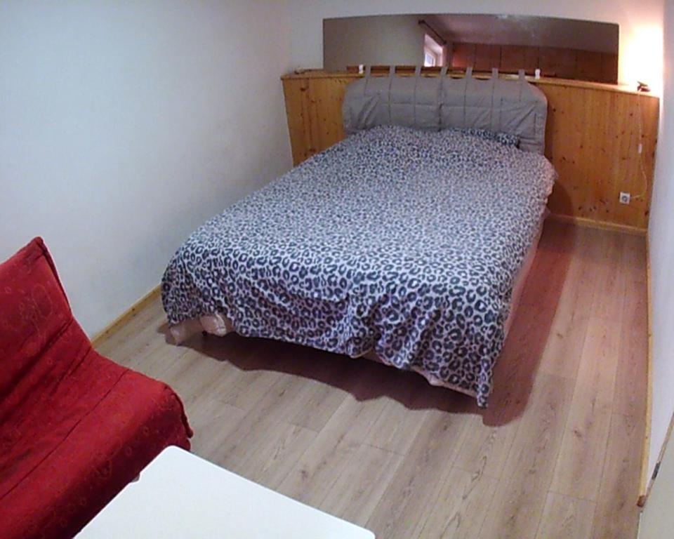 a bedroom with a bed and a red couch at maison bleue in Belfort