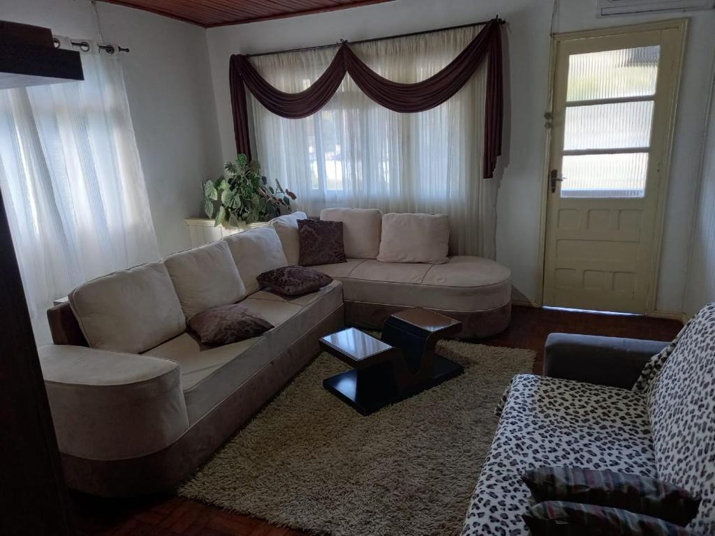 - un salon avec un canapé blanc et une fenêtre dans l'établissement Centro da Cidade Vista para Praça, à Urubici