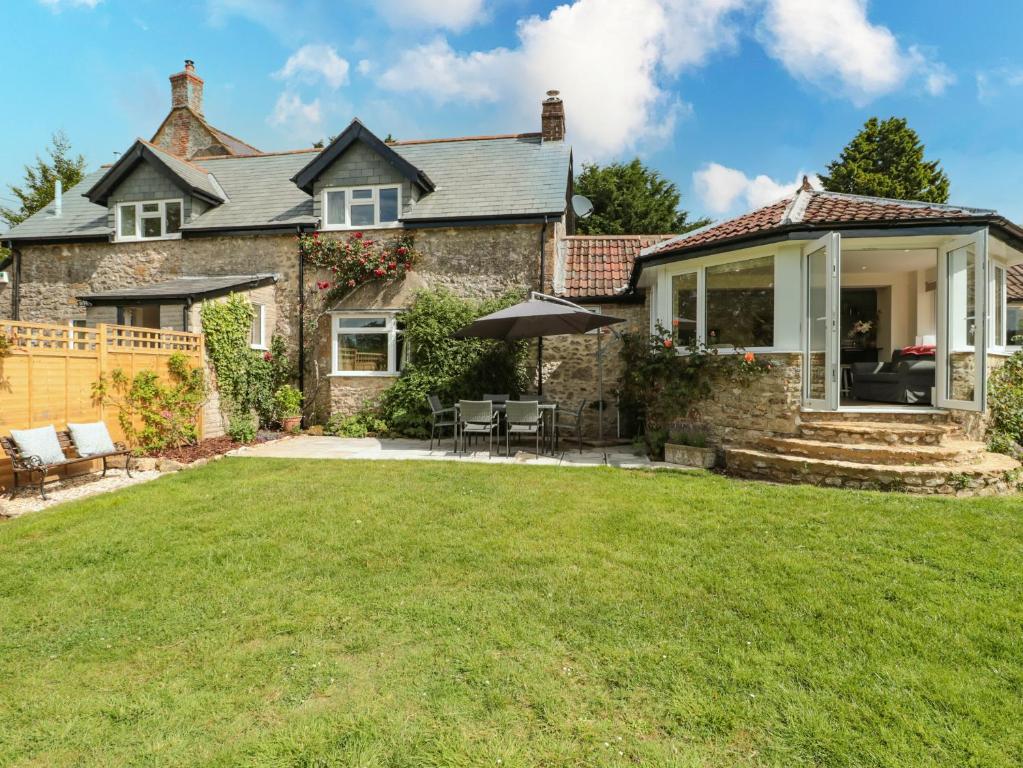 an exterior view of a house with a yard at Ammerham Farm Cottage in Chard