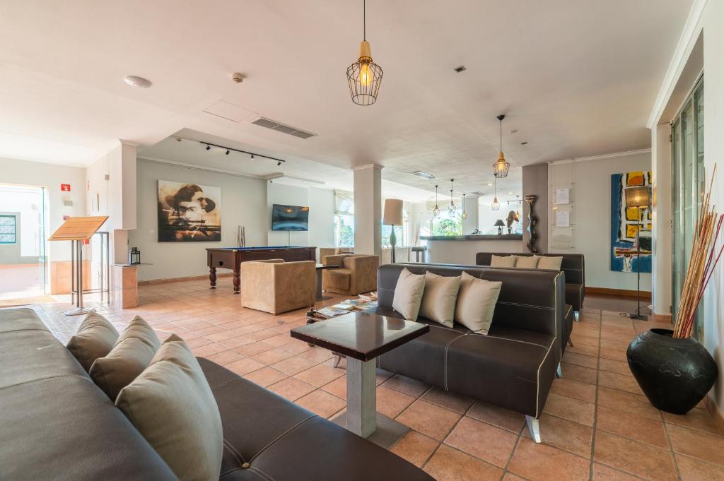 a living room with a couch and a table at Vale d'El Rei Hotel & Villas in Carvoeiro