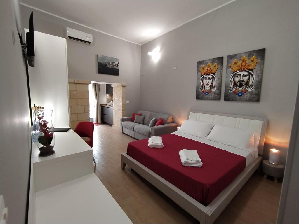 um quarto com uma cama e uma sala de estar em La Punta di Ortigia Holiday Home em Siracusa