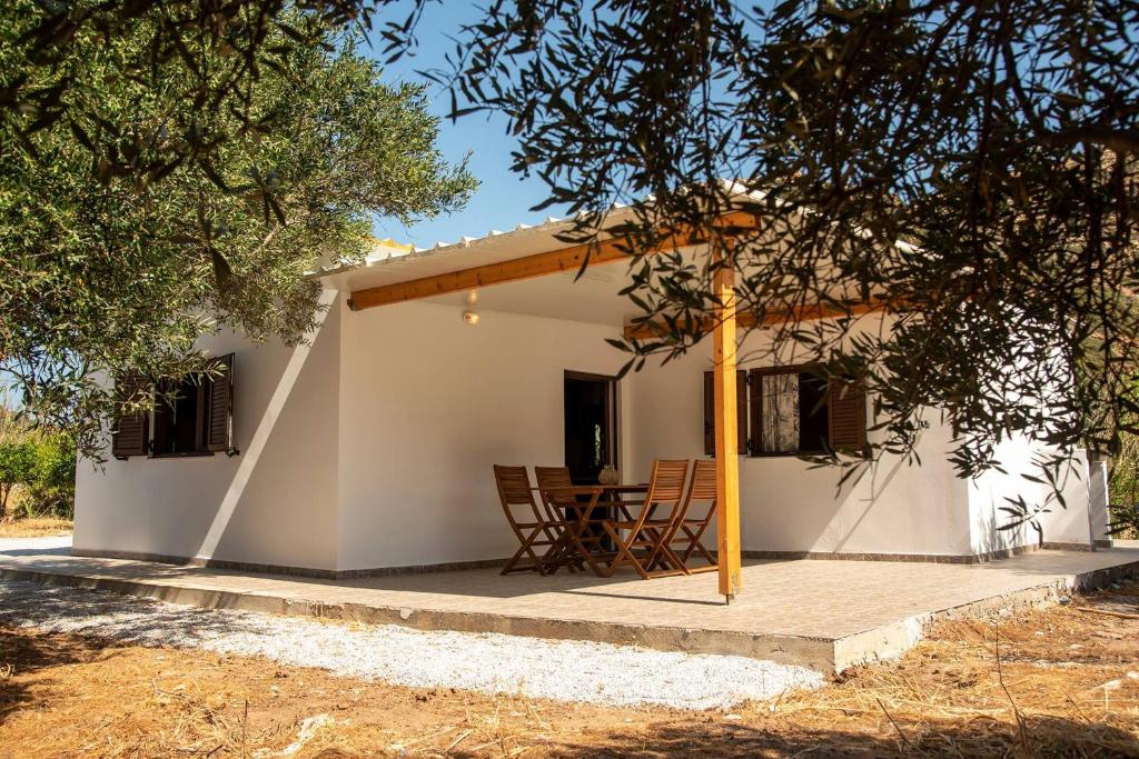 a small white house with a table and chairs at flamingo colour valey house in Palekastron