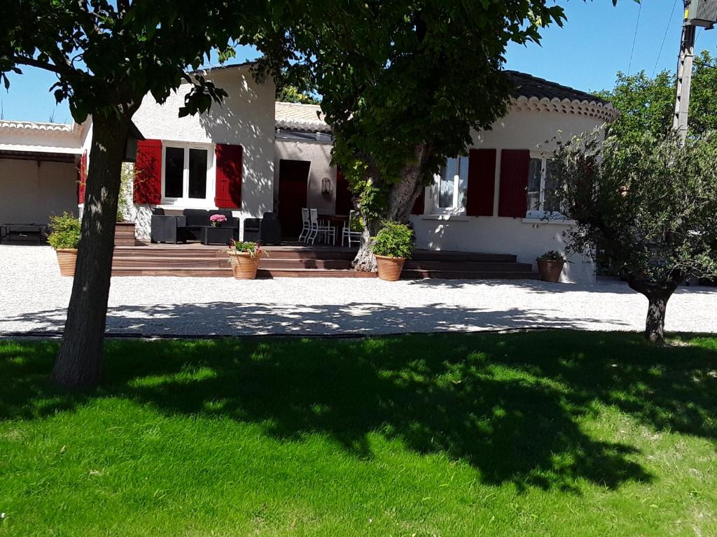 a house with a tree in front of a yard at La Bonbonne en Provence in Travaillan