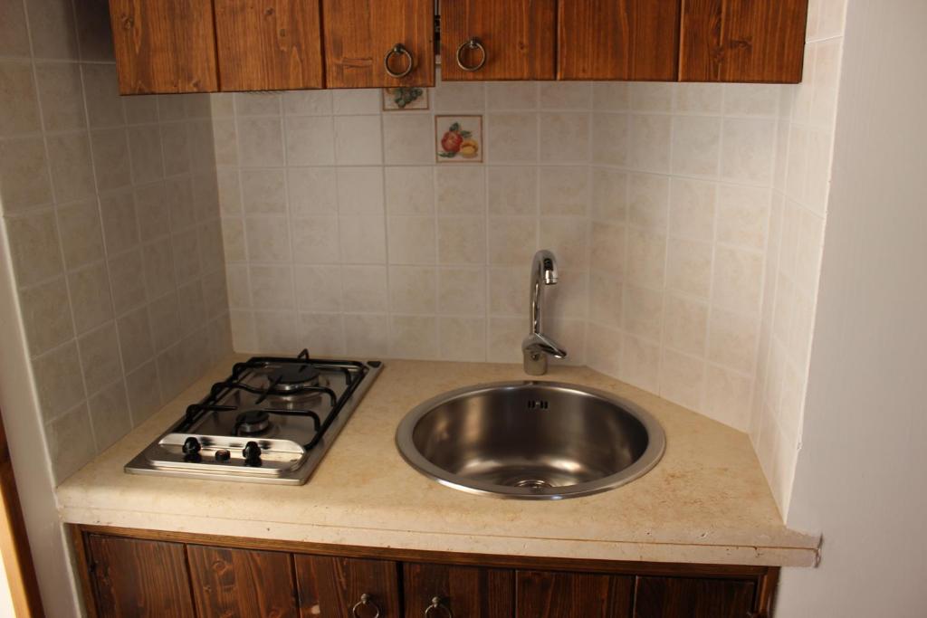 a kitchen counter with a sink and a stove at Masseria Valente in Ostuni