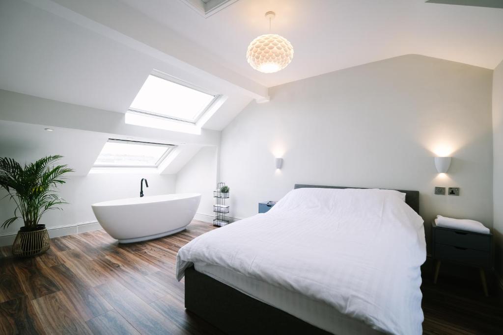 1 dormitorio con cama blanca y bañera en Period Retreat for 6, explore the Lake District en Lancaster