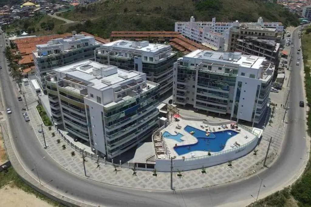 einem Luftblick auf ein Gebäude mit einem Pool in der Unterkunft Apartamento temporada em Arraial do Cabo, Le Bon Vivant in Arraial do Cabo