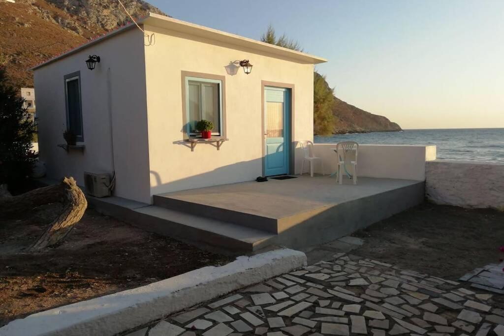 a small white house next to the water at Paradise on Kantouni Beach-20m from Boutique Hotel in Kalymnos