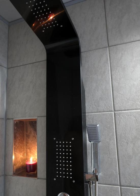 - czarny prysznic ze świecą w łazience w obiekcie művészház apARTman w Balatonfüred
