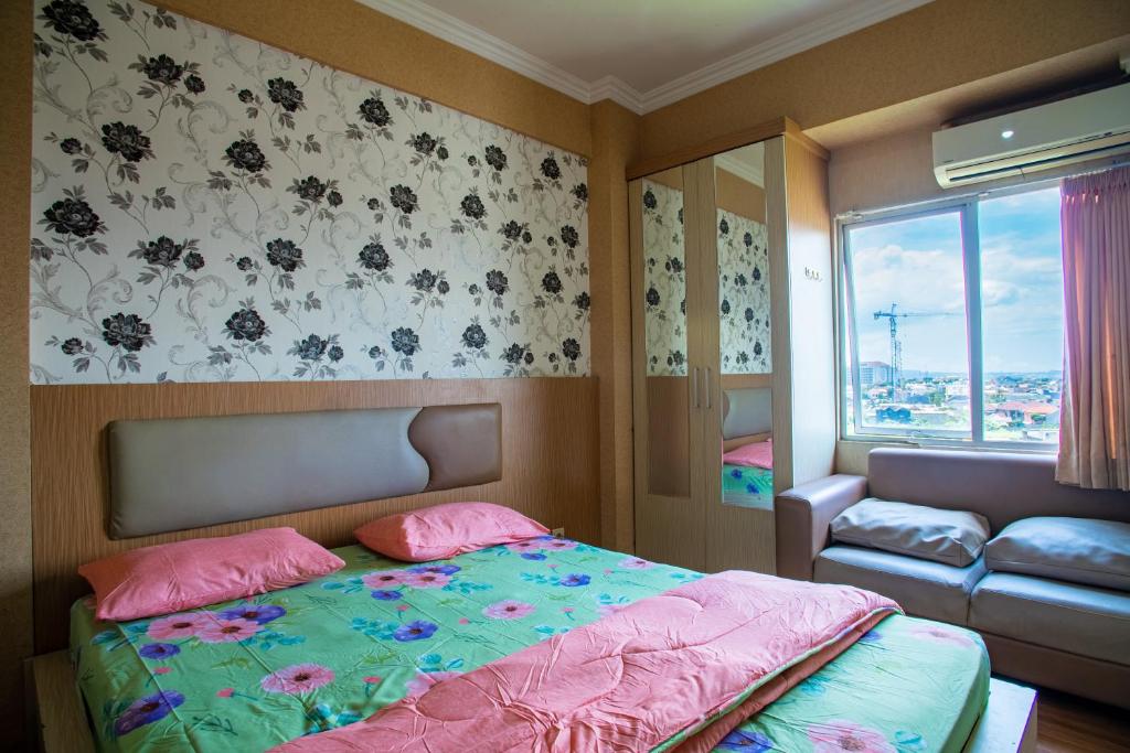1 dormitorio con cama, sofá y ventana en Apartemen Soekarno Hatta by C Management 3, en Malang