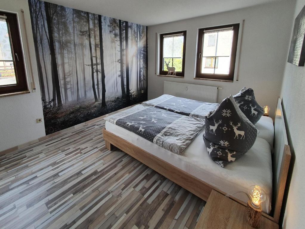 a bedroom with a bed and two windows at Ferienwohnung "Waldzauber" in Bärenstein