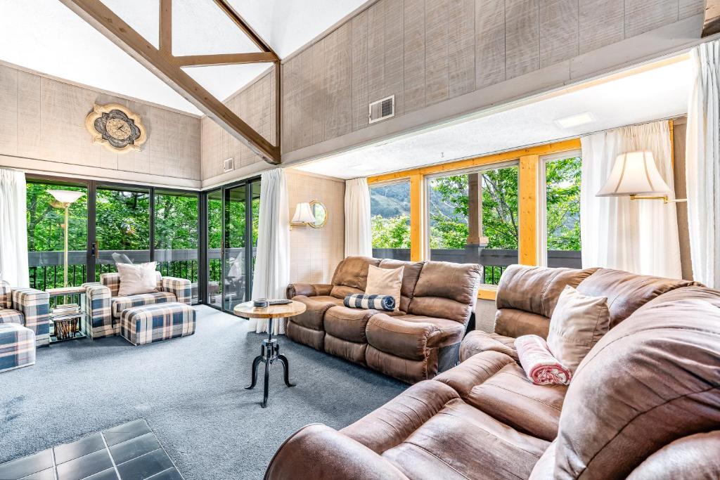 a living room with a couch and chairs and windows at Skiway in Beech Mountain