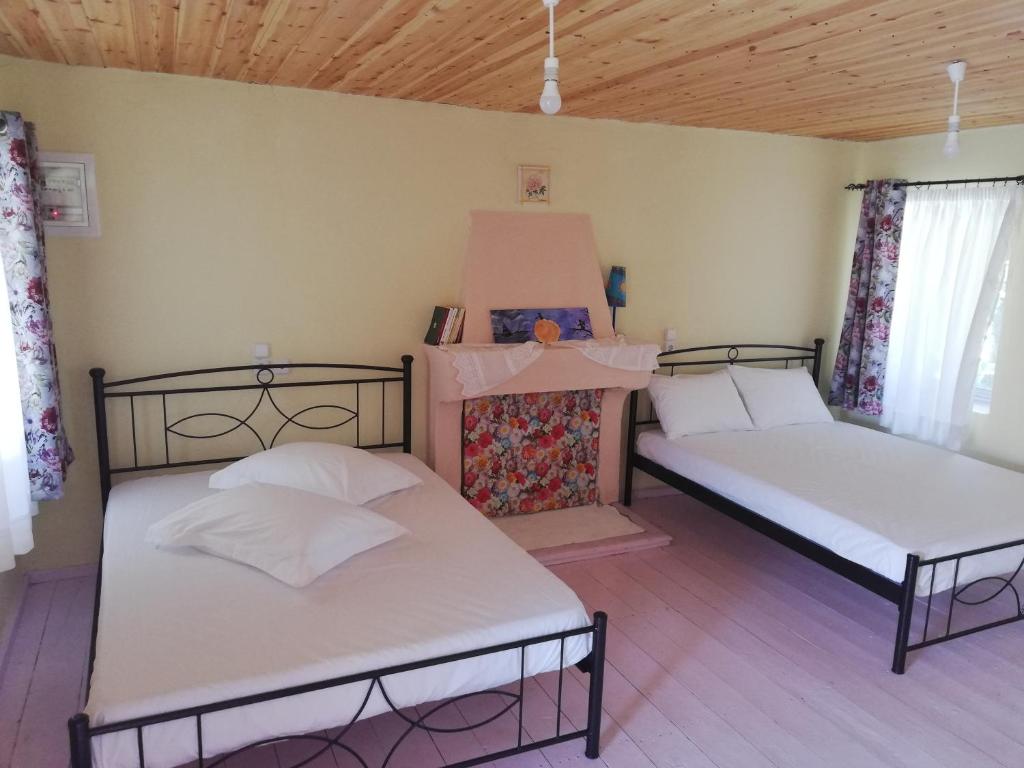 two beds sitting in a room with wooden ceilings at North Evia Kiki's house in Kourkouloí