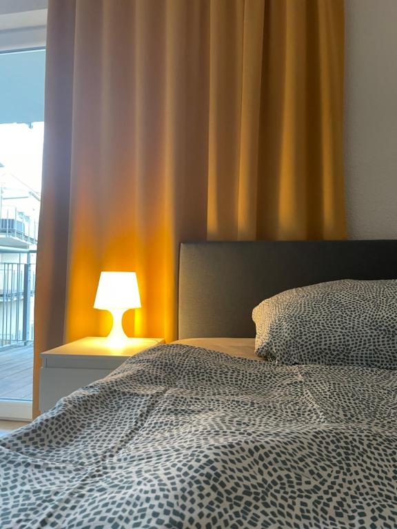 a bedroom with a bed and a lamp next to a window at NorthApartments Dresden in Dresden