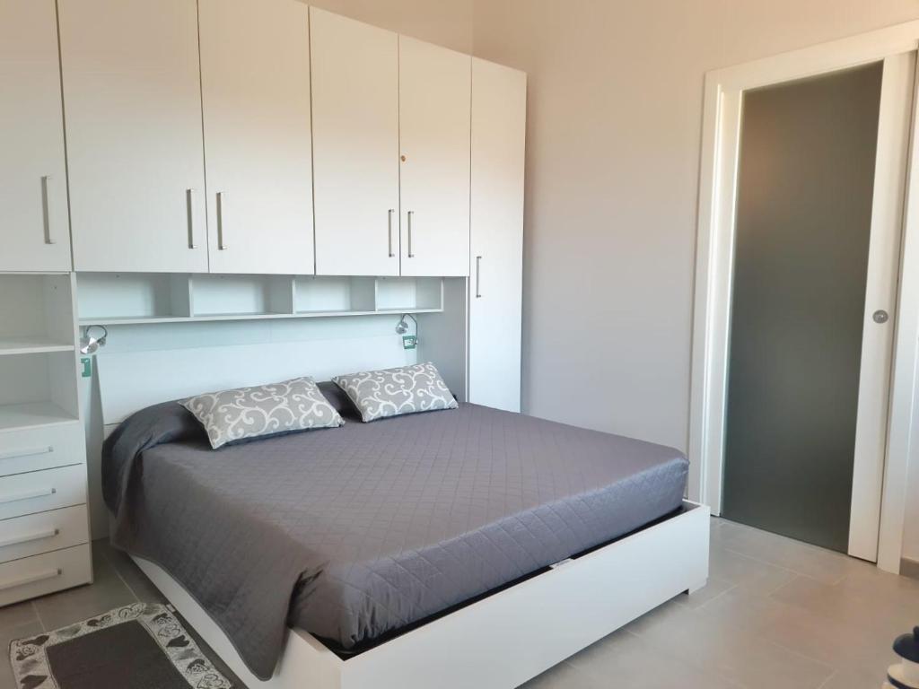 una camera con letto e armadi bianchi di Monolocale Arbus R0478 ad Arbus