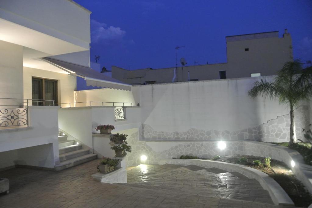 - une vue nocturne sur un bâtiment avec une piscine dans l'établissement Salento Holiday, à San Cassiano