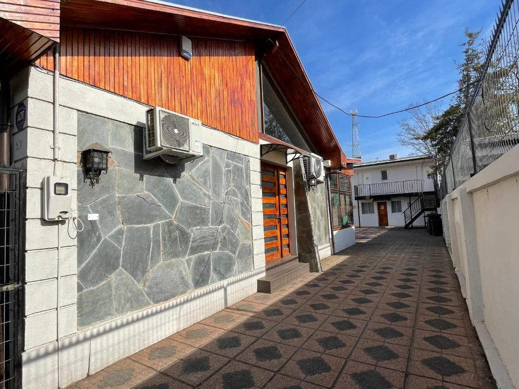 um edifício com uma parede de pedra ao lado de uma rua em Residencial Astorga em Rancagua