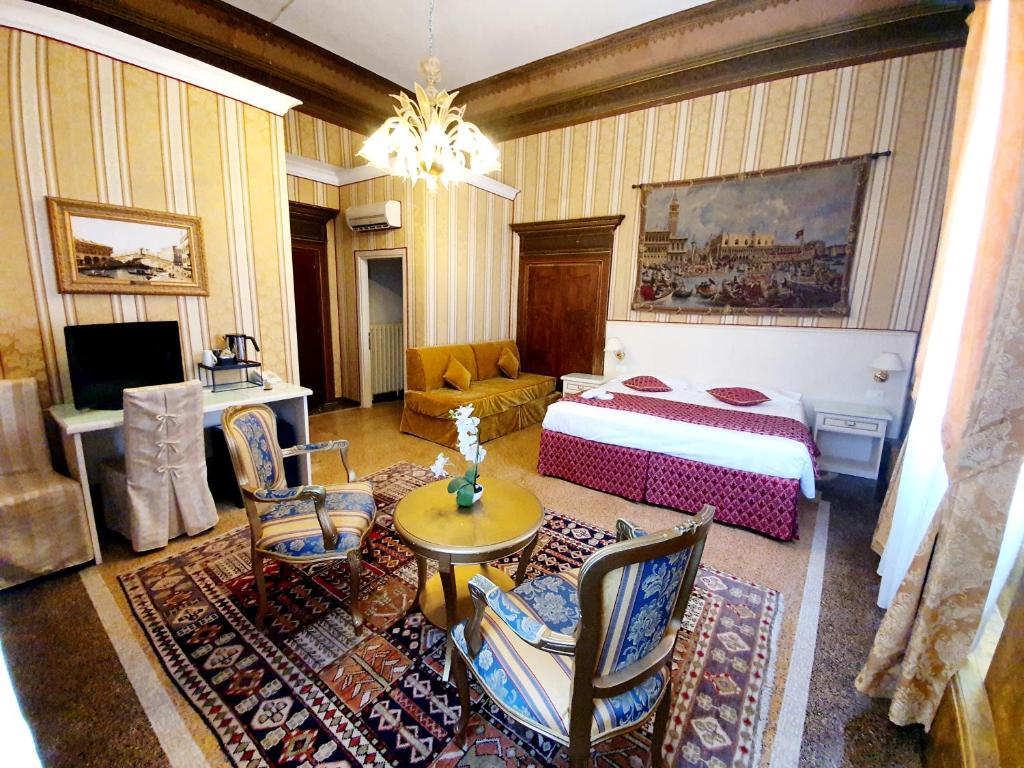 1 dormitorio con 1 cama, mesa y sillas en Hotel Corte dei Greci en Venecia