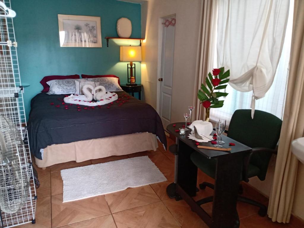 a bedroom with a bed and a table and a chair at Loft Estudio El Faro - Zona Estero Beach in Ensenada