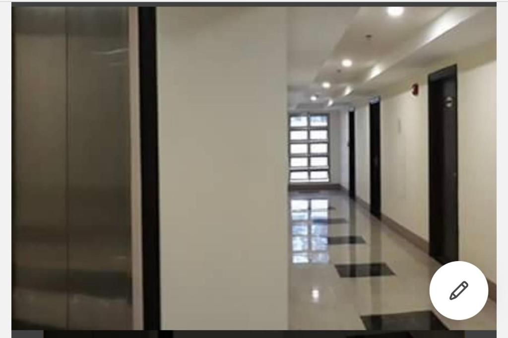 un couloir d'un bâtiment avec une porte en verre dans l'établissement Cozyminium 1 at MEGATOWER Baguio, à Baguio