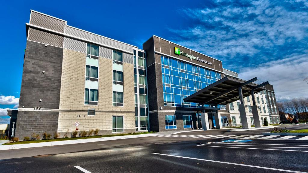 un bâtiment situé dans une rue avec une route en face de celle-ci dans l'établissement Holiday Inn Express & Suites Vaudreuil-Dorion, an IHG Hotel, à Vaudreuil-Dorion