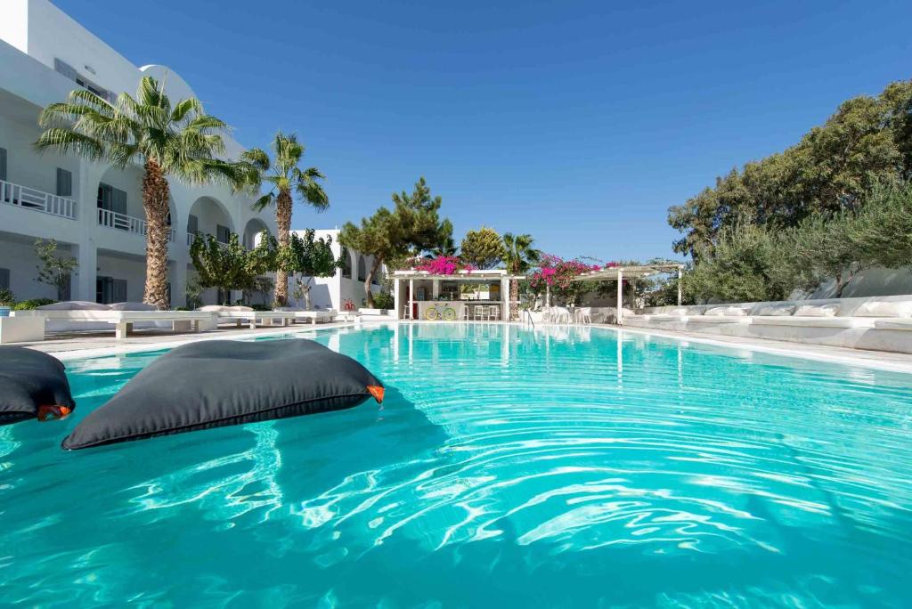 a swimming pool with two pillows in the water at Hotel 28 in Kamari