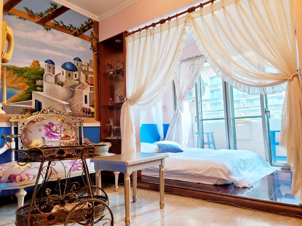 a bedroom with a bed and a window at Migo House in Kaohsiung