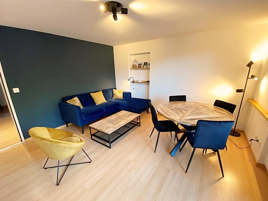 ein Wohnzimmer mit einem blauen Sofa und einem Tisch in der Unterkunft Seeblick an Luxusmeile 4P, 70m2 - Parkplatz, - S11-1 in St. Moritz