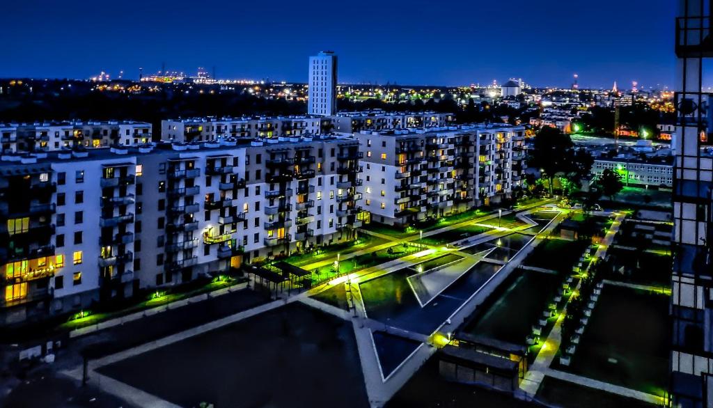 uitzicht op een stad in de nacht met gebouwen bij SUNRISE HOME APARTMENTS - LIGHTHOUSE in Gdańsk